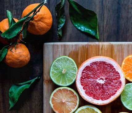 assorted sliced citrus fruits on brown wooden chopping board